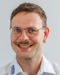 Bild von Karl Wilhelm, junger Mann mit leichtem Lächeln und Brille